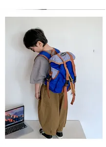 Detail view of child wearing the blue and grey canvas backpack with contrast brown straps