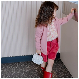 Mädchen mit kleiner weißer Handtasche mit 3D-Hasenrelief und stilvollem Herbstoutfit