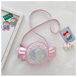 Detail of pink child crossbody bag with shell pattern and decorative bow accents