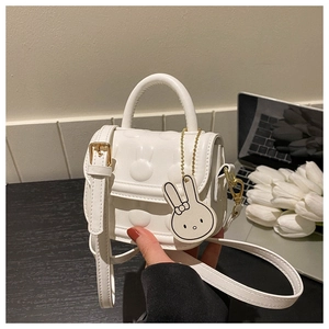 Detailansicht der weißen Mini-Handtasche mit Hasenohren-Relief und verstellbarem Riemen