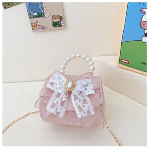 Détail du sac à main en dentelle rose pour filles avec nœud papillon et anse en perle