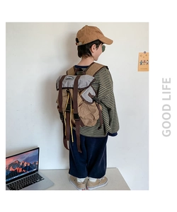Detail view of khaki and grey canvas kids backpack with drawstring and side buckles