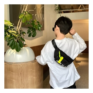 Détail de sac de poitrine enfant avec sangle jaune fluo et boucle réglable vue de dos
