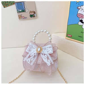 Détail du sac fille en dentelle rose avec grand nœud blanc et poignée en perles