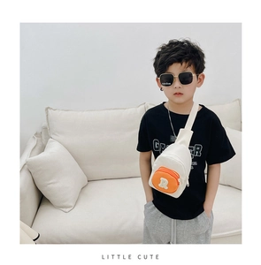 Détail du sac de poitrine pour enfants en toile avec poche orange et écusson lettre B
