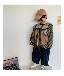 Detail of child outdoors backpack with brown canvas texture and adjustable buckles