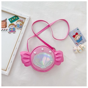 Detail view of pink candy-shaped girls bag with shell design and pearl accents