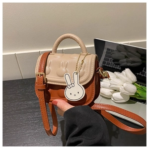 Detail der Kinder-Mini-Tasche mit niedlichem Hasenrelief und Anhänger im Lifestyle-Stil