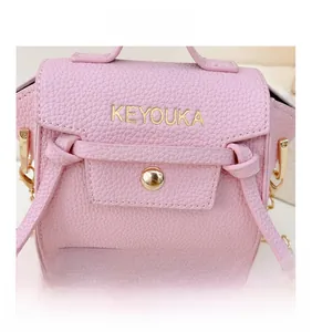 Dettaglio della mini borsa in pelle rosa con catena dorata e logo del marchio