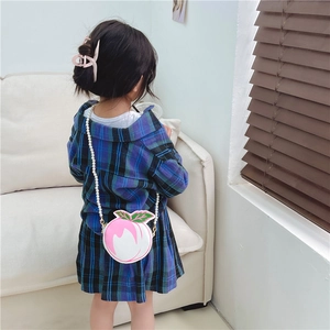 Pink peach-shaped girls crossbody bag with pearl strap on plaid dress child model