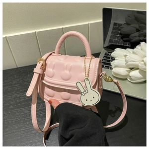 Detail der rosa PU-Leder Mädchentasche mit Hasenprägung und süßem Hasenanhänger
