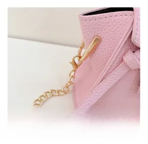 Dettaglio borsa in pelle rosa con gancio in metallo dorato rimovibile e tracolla a catena