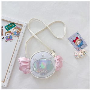 Detailed view of a white candy-shaped kids bag with shell decor and pink satin ruffles