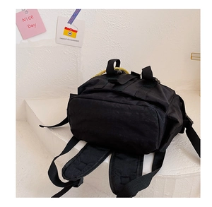 Detail of adjustable shoulder straps and wide reinforced base on a black canvas kids backpack