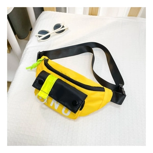 Détail d'un sac de poitrine en nylon jaune avec boucle magnétique noire et lettrage BNU