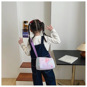 Detail of child wearing a mermaid print cylindrical canvas bag with purple strap