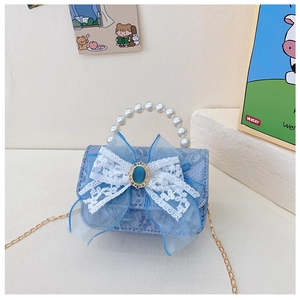 Détail du sac à main enfant en dentelle bleue avec poignée en perles et nœud élégant