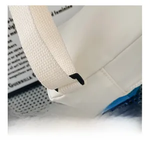 Gros plan de la couture triangulaire renforcée et boucle sur sac en toile blanc