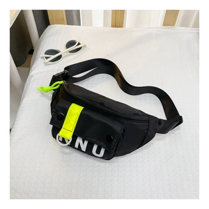 Détail du sac de poitrine en toile noire avec lettres ONU et touches vert fluo