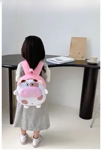 Vue détaillée du sac à dos vache rose et blanc porté par un enfant en décor intérieur