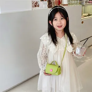 Girls stylish mini green PU crossbody bag with pink button and long shoulder strap