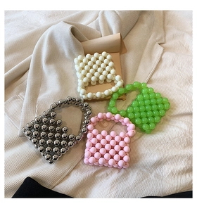 Flat lay of handmade beaded mini handbags in silver, white, green and pink colors