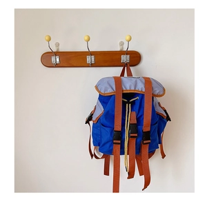 Detail of blue outdoor kid backpack with contrasting orange straps and grey lid pockets