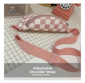 Détail du sac de poitrine à damier rose avec sangle réglable et fermeture à glissière