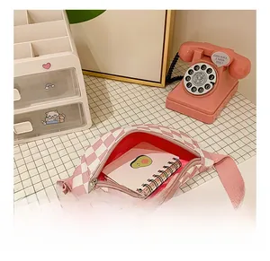 L'intérieur du sac damier rose montre la capacité de rangement pour papeterie et notes