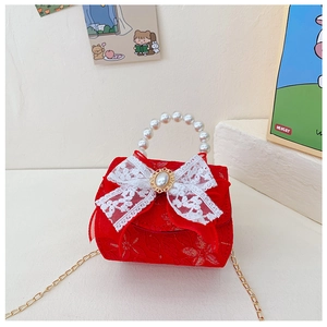 Détail de broderie florale rouge sur sac enfant avec poignée en perles et nœud