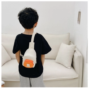 Vue détaillée du sac bandoulière enfant crème et orange avec écusson lettre R