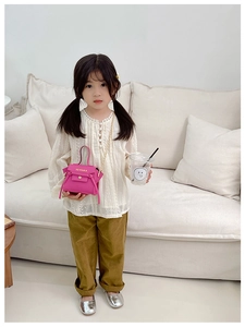 Dettaglio mini borsa a tracolla fucsia per bambine con logo e catena in metallo oro
