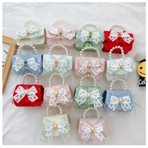 Vue à plat de mini sacs à perles colorés avec nœuds en dentelle et tissu texturé