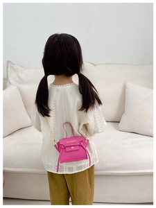 Dettaglio della mini borsa rosa con trama in pelle e tracolla a catena dorata