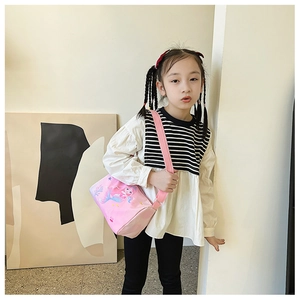 Detailed view of pink cylindrical kids shoulder bag with mermaid cartoon illustration