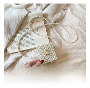 Close-up of a woven pearl mini crossbody bag with a golden metal pearl clasp