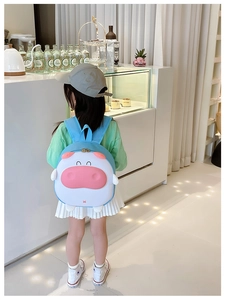Vue détaillée du sac à dos 3D vache de dessin animé bleu ciel sur une petite fille