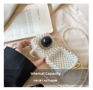 Detail view of the mini pearl woven bag showing internal capacity with perfume inside