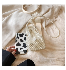 Detailed macro view of handmade mini pearl woven bag with glossy beads and chain strap