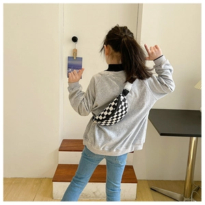 Détail du sac de poitrine à carreaux pour enfants avec sangle réglable sur un mannequin