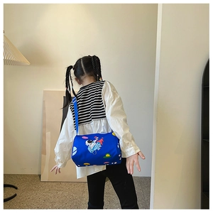 Rear view of a child wearing a blue space-themed cylinder shoulder bag with astronaut prints