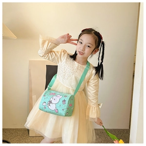 Detail of mint green cylindrical kids canvas bag with cute rabbit illustration and strap