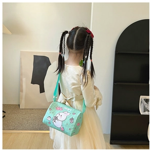 Rear view of a child wearing a mint green canvas crossbody bag with cute rabbit patterns