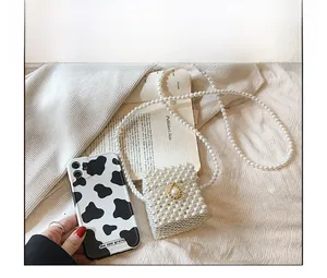 Detail of girl's mini pearl beaded square bag with a cow grain phone case accessory