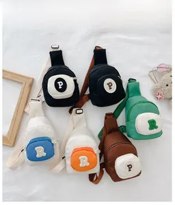 Vue à plat de divers sacs de poitrine en nylon pour enfants avec broderie de lettres