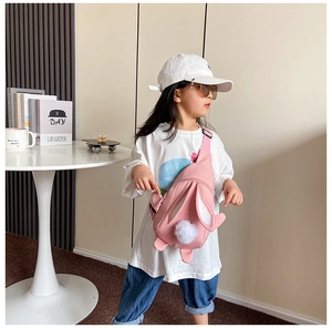 Detailansicht der rosa Kaninchen-Brusttasche mit süßen Ohren und Bommel am Kindermodel