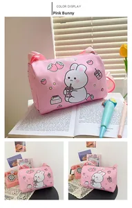 Detail view of pink canvas rabbit bag on a book with strawberry and milk tea pattern