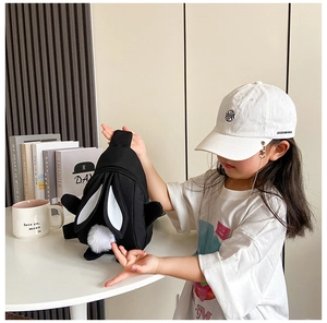 Detail einer süßen schwarzen Hasen-Kindertasche aus Nylon und einer modischen Baseballkappe