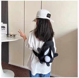 Detail der süßen Pinguin-Mini-Brusttasche für Kinder aus schwarzem Canvas mit Plüschkugel