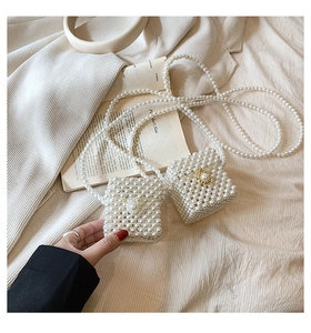 Detail of girls mini pearl crossbody bag featuring handmade woven beads and chain strap